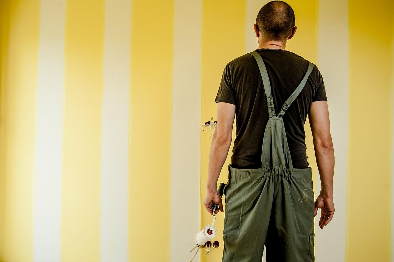 Wall with freshly painted vertical yellow and white stripes